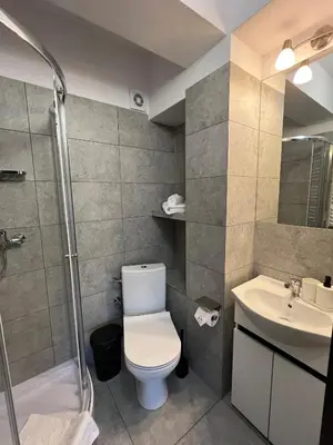 a kitchen with white cabinets and a brown door at Krakstop apartamenty in Kraków