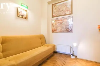 a living room with a couch and paintings on the wall at Big cozy apartment Free 1 parking in Kraków