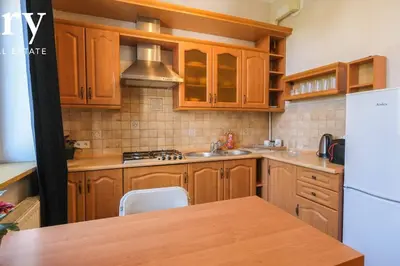 a kitchen with wooden cabinets and a sink and a refrigerator at Big cozy apartment Free 1 parking in Kraków