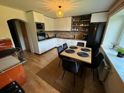 a kitchen with a wooden table and black chairs at Słoneczne Wzgórze w Kojszówce in Kojszówka