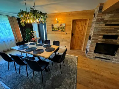 a dining room with a table and chairs and a fireplace at Słoneczne Wzgórze w Kojszówce in Kojszówka