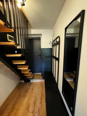 a hallway with wooden stairs and a blue door at Słoneczne Wzgórze w Kojszówce in Kojszówka