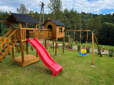 a wooden playground with a slide and a gazebo at Słoneczne Wzgórze w Kojszówce in Kojszówka