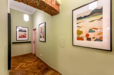 a hallway with three paintings on the walls at Pastell Apartments in Kraków