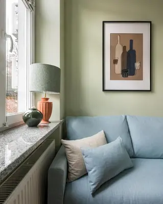 a blue couch in a living room with a window at Pastell Apartments in Kraków