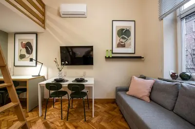 a living room with a couch and a table and chairs at Pastell Apartments in Kraków