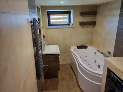 a bathroom with a tub and a sink at Pokoje jacuzzi in Zator