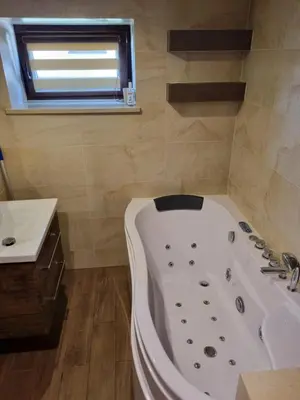 a bathroom with a bath tub and a sink at Pokoje jacuzzi in Zator