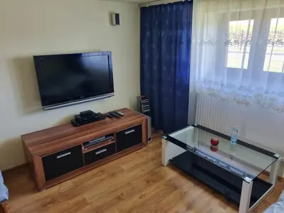 a living room with a flat screen tv and a coffee table at Pokoje jacuzzi in Zator