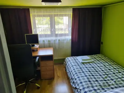 a bedroom with a bed and a desk with a computer at Pokoje jacuzzi in Zator
