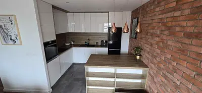 a living room with a white couch and a kitchen at Apartament nad Wisłą in Kraków