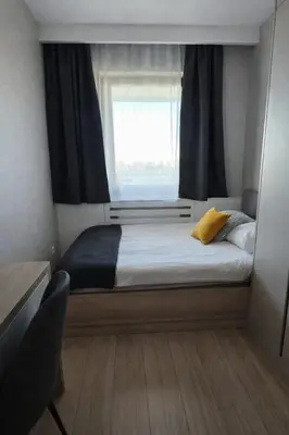 a small bedroom with a bed with a window at Apartament nad Wisłą in Kraków