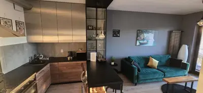 a living room with a green couch and a bed at Apartament nad Wisłą in Kraków