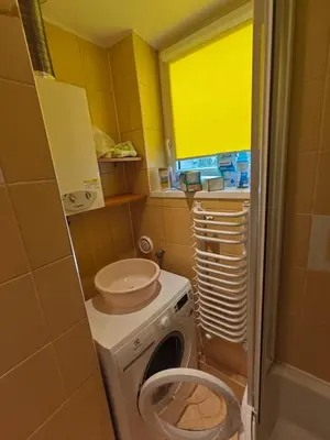 a bathroom with a washing machine and a sink at Krakow Avenu 29 november 2 room in Kraków