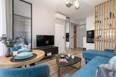 a living room with a blue couch and a table at Lux Kraków Apartment with Parking & AC just 1,5 km from Main Square by Renters Prestige in Kraków