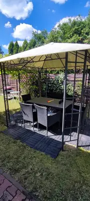 a gazebo with a table and chairs under it at Stylowy Apartament z ogrodem in Gorenice