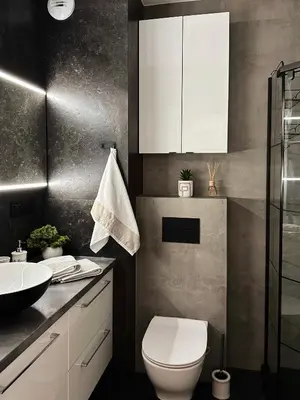 a bathroom with a white toilet and a sink at Apartamenty FIGARETTI in Kraków