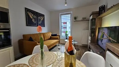 a living room with a table and a couch at Apartamenty FIGARETTI in Kraków