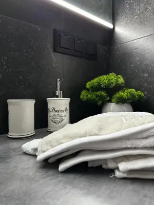 a bathroom counter with towels and a bottle of soap at Apartamenty FIGARETTI in Kraków