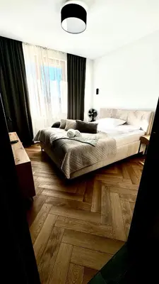 a bedroom with a large bed and a wooden floor at Forum Apartment in Kraków