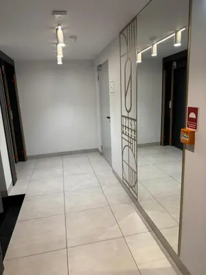 a hallway with a door and a tile floor at Forum Apartment in Kraków