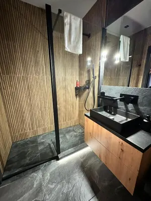 a bathroom with a sink and a shower at Forum Apartment in Kraków