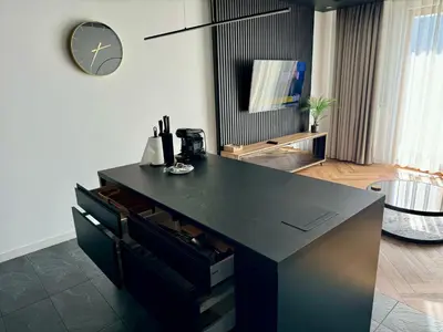 a black counter in a room with a clock on the wall at Forum Apartment in Kraków