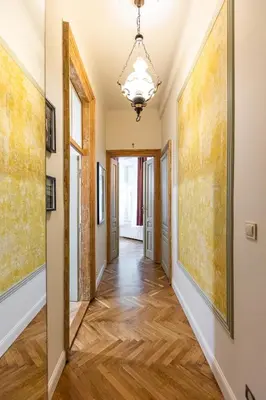 a hallway with paintings on the walls and a chandelier at Stylish apartment #2 in Krakow Old Town in Kraków