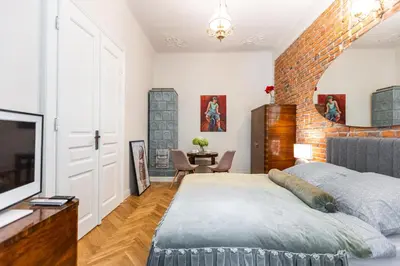 a bedroom with a large bed and a brick wall at Stylish apartment #2 in Krakow Old Town in Kraków