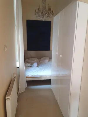 a small bedroom with a bed in a glass cabinet at Szymborska Stradomska 5 in Kraków