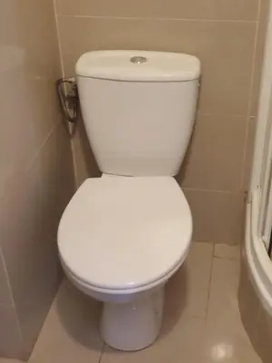 a white toilet sitting in a bathroom next to a tub at Szymborska Stradomska 5 in Kraków