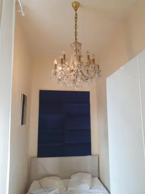 a chandelier hanging over a bed in a bedroom at Szymborska Stradomska 5 in Kraków