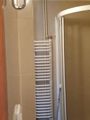 a bathroom with a towel rack next to a mirror at Szymborska Stradomska 5 in Kraków