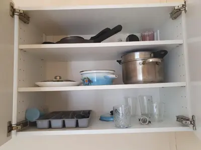 a kitchen shelf with dishes and pots and pans at Szymborska Stradomska 5 in Kraków