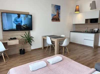 a living room with a table and a tv on the wall at Bosacka Street - Apartament B31 in Kraków