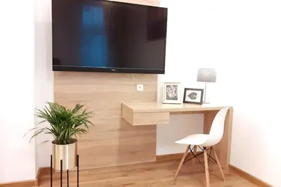 a living room with a tv and a chair and a plant at Bosacka Street - Apartament B26 in Kraków