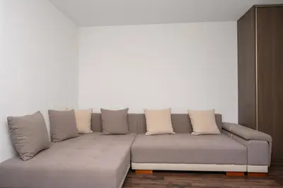 a living room with a gray couch with pillows at RentPlanet - Apartament Mireckiego in Kraków