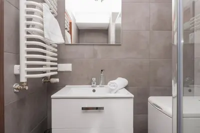 a bathroom with a white sink and a mirror at RentPlanet - Apartament Mireckiego in Kraków