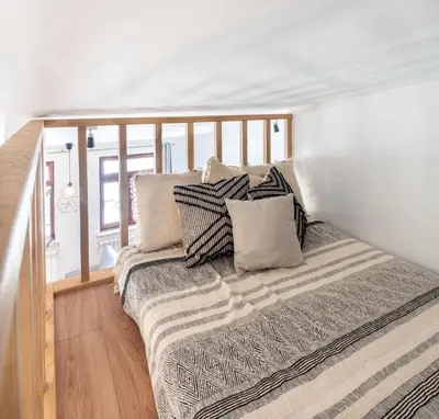 a bed with pillows on it in a room at Kochanowskiego 23 Apartament in Kraków