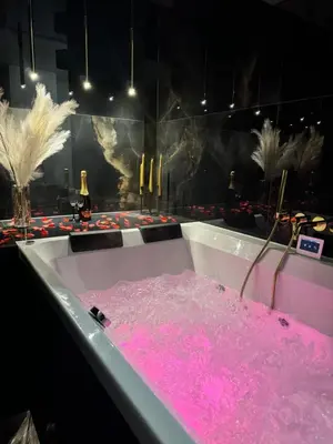 a bath tub filled with pink water in a room at Apartament z jacuzzi, Wiślane Tarasy in Kraków