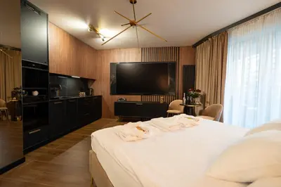 a hotel room with a bed and a flat screen tv at Apartament z jacuzzi, Wiślane Tarasy in Kraków