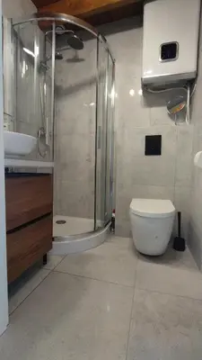 a bathroom with a shower and a toilet and a sink at Yellow Peaked Shoe Apartment in Kraków