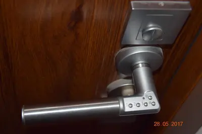 a close up of a metal handle on a door at Yellow Peaked Shoe Apartment in Kraków
