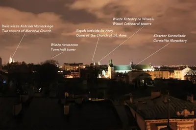 a view of the city at night at Yellow Peaked Shoe Apartment in Kraków