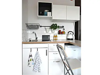 a kitchen with white cabinets and a sink at Yellow Peaked Shoe Apartment in Kraków