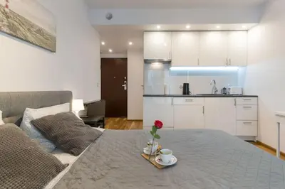 a room with a bed with a tray with a flower on it at Zabłocie Charming Studio A in Kraków