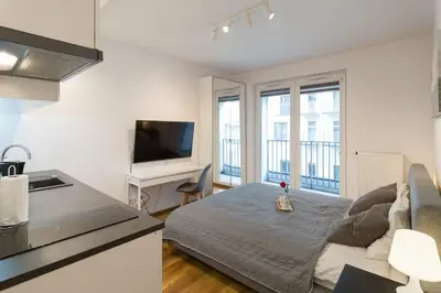 a kitchen and a living room with a bed and a tv at Zabłocie Charming Studio A in Kraków