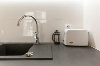 a kitchen counter with a sink and a toaster at Zabłocie Charming Studio A in Kraków