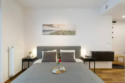 a bedroom with a bed with two cups and flowers on it at Zabłocie Charming Studio A in Kraków