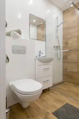 a white bathroom with a toilet and a shower at Zabłocie Charming Studio A in Kraków